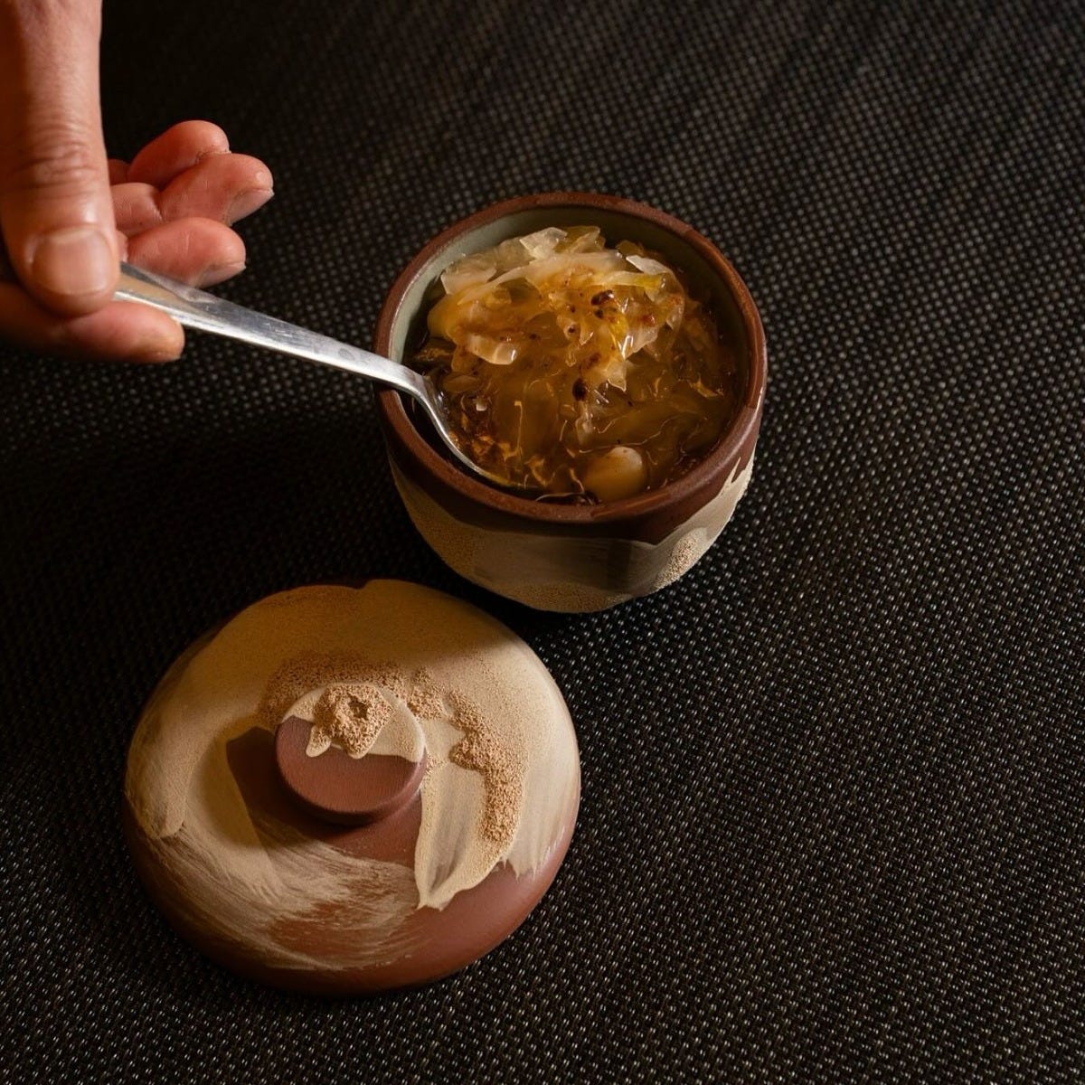 Chef Okay Inak plating Corti Soup in the Coupe Bowl and Lid Set during service at Sora Craft Kitchen restaurant