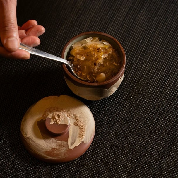 Chef Okay Inak plating Corti Soup in the Coupe Bowl and Lid Set during service at Sora Craft Kitchen restaurant