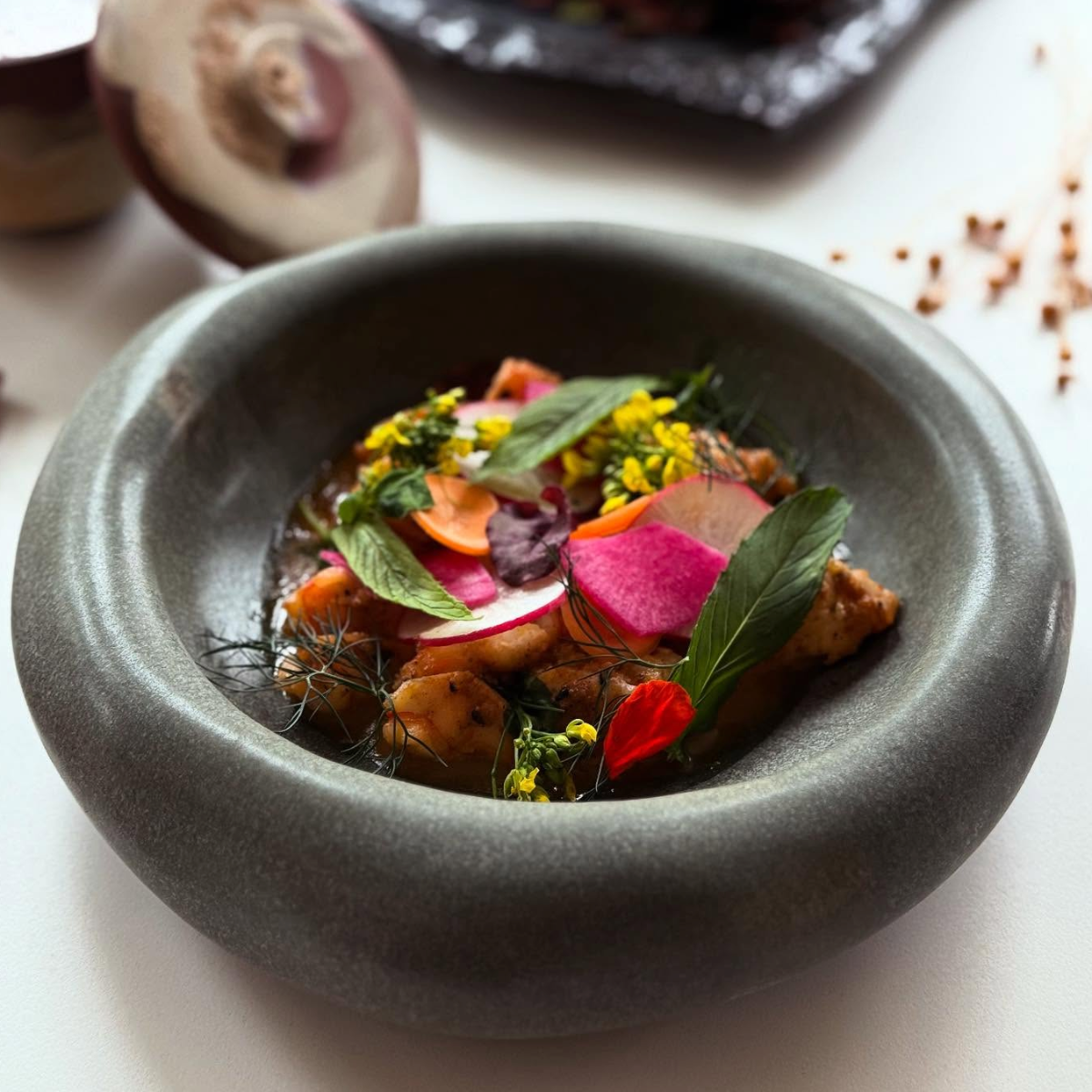 Molin Bowl in matte sage with shrimp in tarhana butter and colorful edible flowers